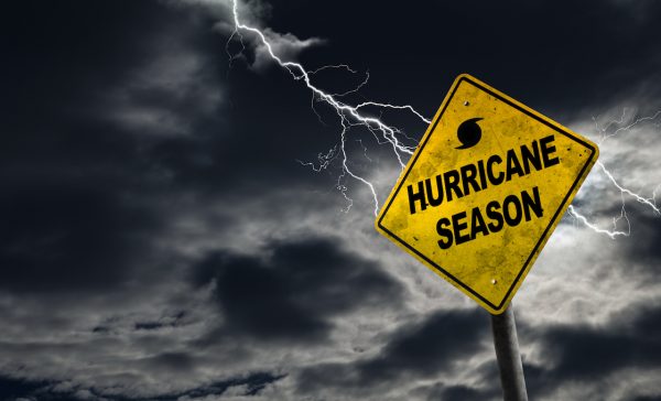 Hurricane season with symbol sign against a stormy background and copy space. Dirty and angled sign adds to the drama.