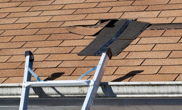 Fixing damaged roof shingles.  A section was blown off after a storm with high winds causing a potential leak.
